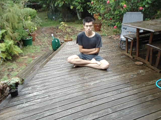 Still from video, Tom Hackshaw sitting outside waiting for cyclone to arrive.